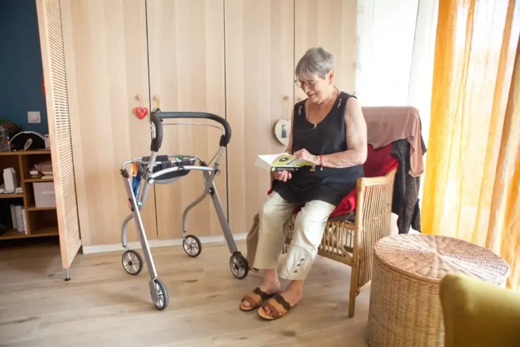 Une résidente profite d’un moment de lecture dans sa chambre lumineuse et confortable à la résidence senior Domani.