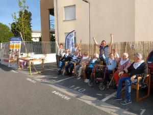 Habitants et équipe de la résidence senior Domani à Albi réunis devant la résidence lors d'un moment convivial en extérieur.